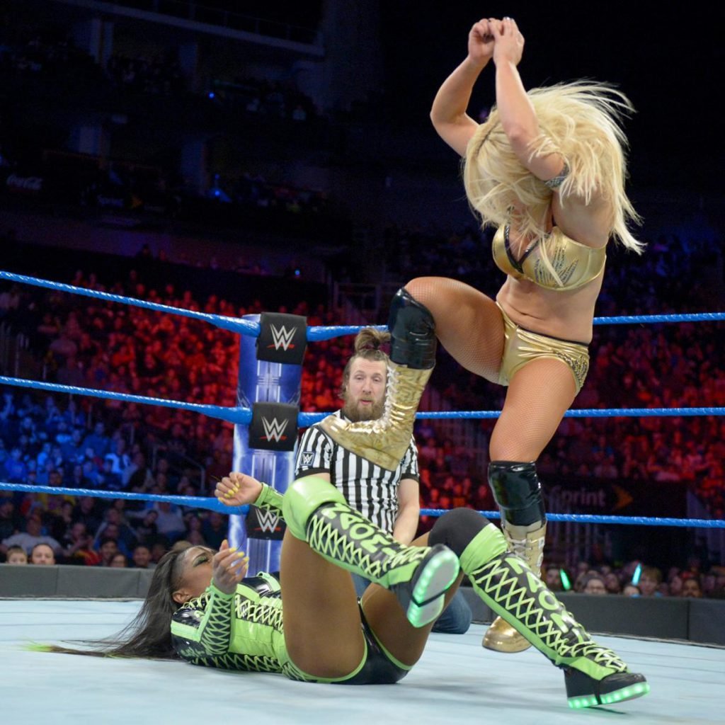 Mandy Rose stomping Naomi while referee Daniel Bryan looks on with concern