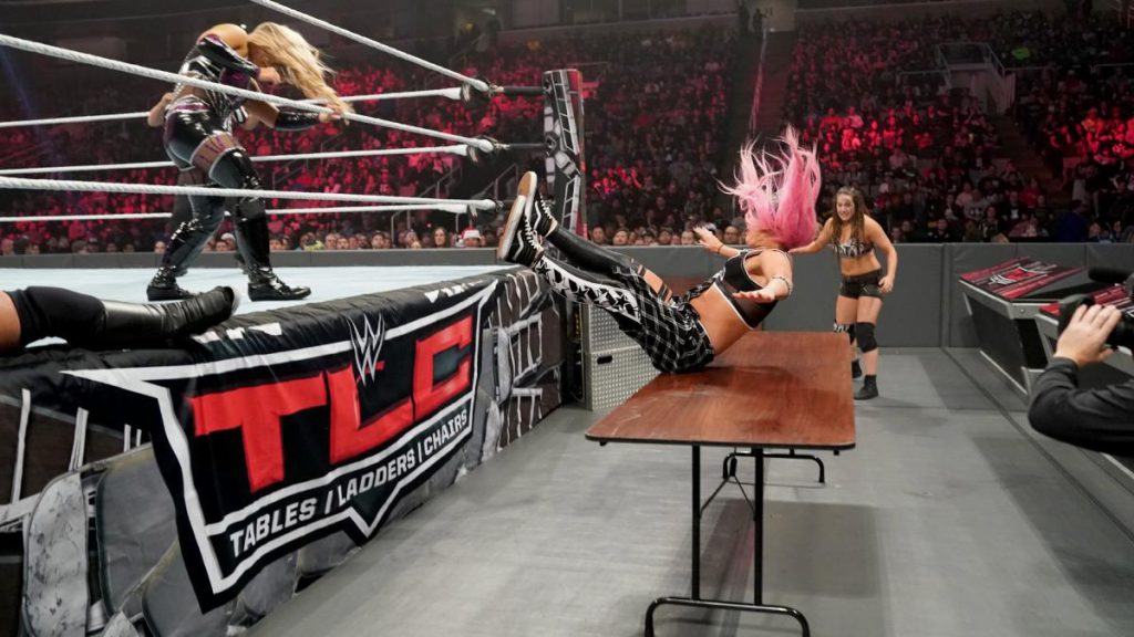 Ruby Riott puts Liv Morgan of Ruby Riott's Squad through a Table as Sarah Logan looks on in horror at WWE TLC